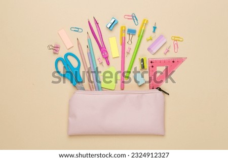 Pink pencil case with school stationery on color backgroung, top view Royalty-Free Stock Photo #2324912327