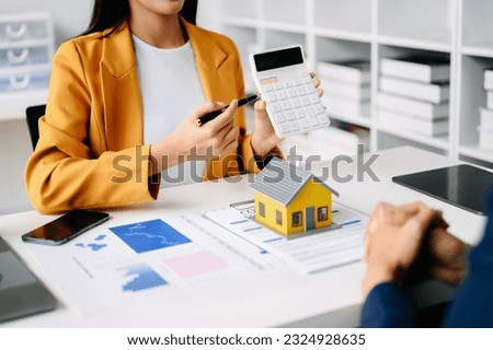 Real estate broker agent presenting and consult to customer to decision making sign insurance form agreement, home model, concerning mortgage loan offer 