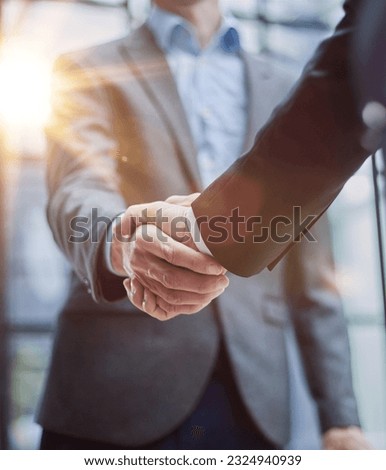 Two diverse professional business men executive leaders shaking hands at office meeting Royalty-Free Stock Photo #2324940939