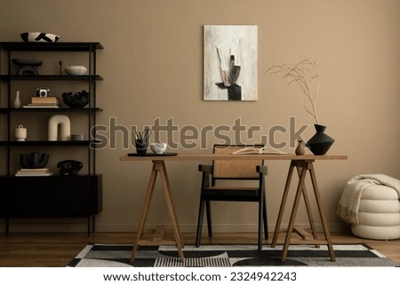 Cozy composition of workplace interior space with mock up poster frame, wooden desk, rattan chair, black lamp, books, patterned carpet, marble bowl and personal accessories. Home decor. Template.  Royalty-Free Stock Photo #2324942243