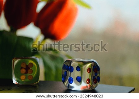 Transparent dice on the background of a window and a bouquet of red peonies Royalty-Free Stock Photo #2324948023