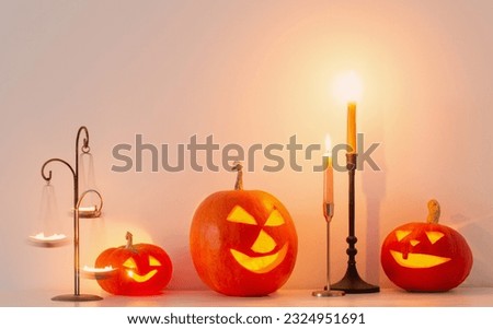 halloween pumpkins with burning candles in white interior
