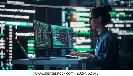 Female Developer Thinking and Typing on Computer, Surrounded by Big Screens Showing Coding Language. Professional Programmer Working in an Office, Running Coding Tests. Futuristic Programming