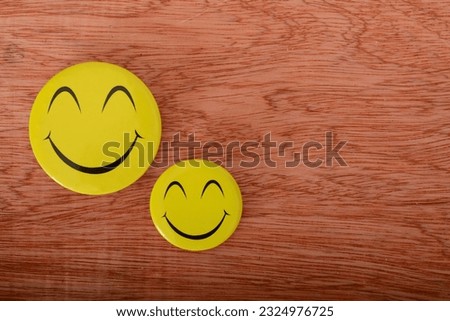 Yellow happy face with smile isolated on a wooden background.