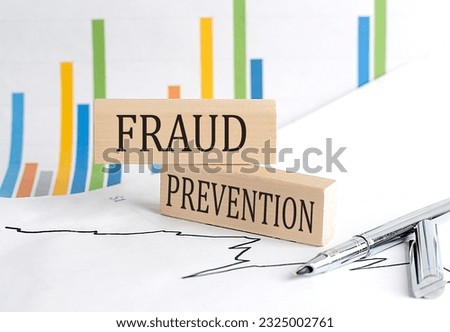 FRAUD PREVENTION text on wooden block on chart background , business concept