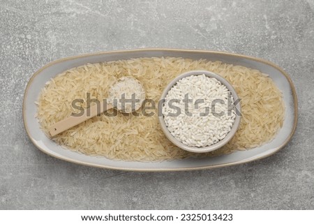 Different sorts of rice on grey table, top view