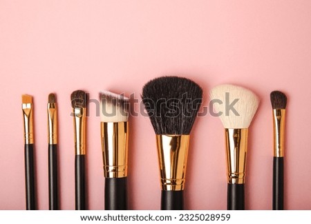 Cosmetic makeup brush on a pink background. Cosmetic product for make-up. Creative and beauty fashion concept. Fashion. Collection of cosmetic makeup brushes, top view, banner.Place for text. MOCAP. Royalty-Free Stock Photo #2325028959