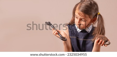 Confused young girl holding big key and small lock as symbo of bad password, security and password management. Copy space for text or design.
