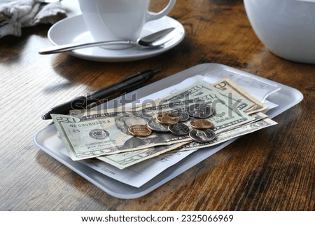 Paying for your bill tab at a restaurant cafe with cash money. Royalty-Free Stock Photo #2325066969