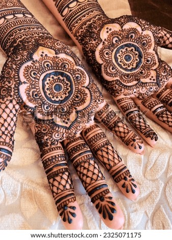 Traditional henna art tattoo on the hands. Bridal mehndi. Indian wedding tradition. Creamy background.