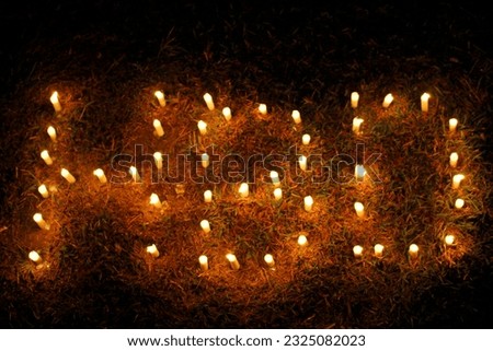 Candles strung on the ground at night become the words HBD which means happy birthday