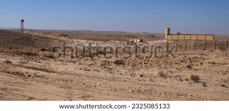 Egyptian border outpost as seen from Israeli patrol road 10, restricted military zone along the border between Israel and Egypt. The border barbed wire fence along the road 10. Egyptian watchtower. Royalty-Free Stock Photo #2325085133