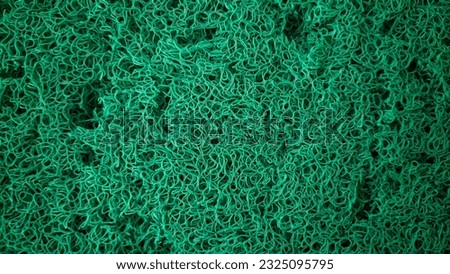 Abstract green plastic fiber in backlight, abstract texture background. High resolution photography. Surface covered with green plastic fibers. 