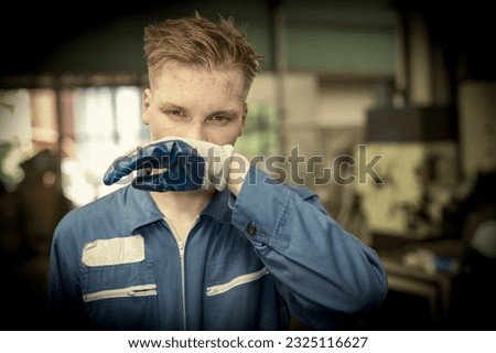 Factory worker close the nose because of chemical leak and safety first concept. Man in toxic factory. Biohazard. Engineer man in danger chemical in construction or factory or garbage industry area. 