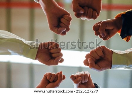 Group of young Engineer United stack hands or join hand teamwork together with Spirit diversity solidarity team Partner in metal sheet factory. Joins hands together teamwork meetings empower.