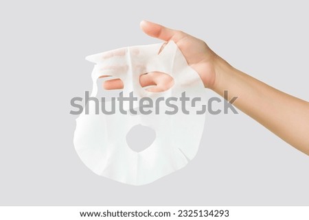 hand holding moisturising face mask isolated on gray background Royalty-Free Stock Photo #2325134293