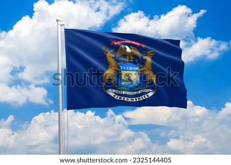 Michigan flag waving in the wind on clouds sky. High quality fabric. International relations concept