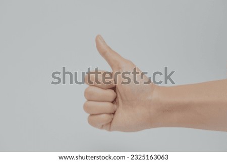 Thumb up gesture on white background.