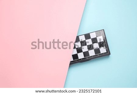 Chessboard on a blue-pink pastel background. Top view