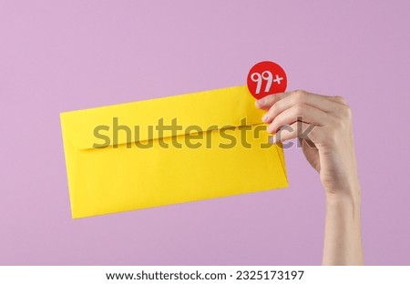 Woman's hand holds yellow paper envelope with notification on purple background