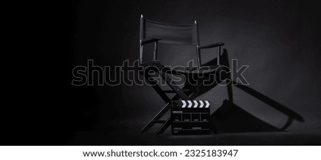 Black director chair and Clapper board or slate on black background. Royalty-Free Stock Photo #2325183947