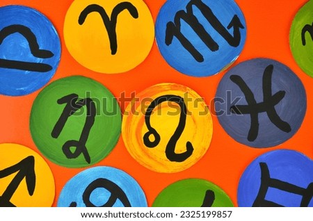 Different round astrology (zodiac) signs on an orange background