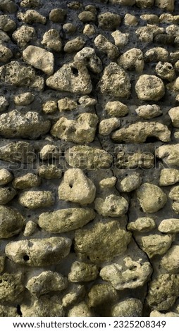 a collection of stones arranged neatly and glued together using cement so that they become a solid wall