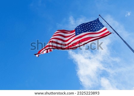 American Flag blowing in the wind with a blue sky, USA American Flag. Waving United states of America famous flag in front of blue sky. Independence Day, Labor day, Flag Day - American Celebration