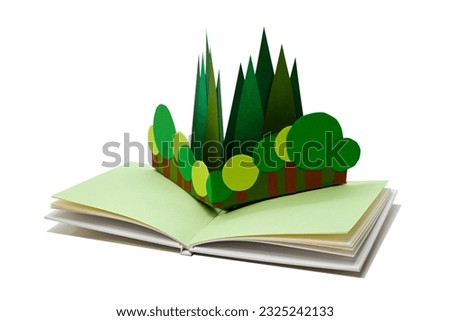 Trees in a pop-up picture book, isolated on white. (The paper craft in the book was made by myself.) Royalty-Free Stock Photo #2325242133
