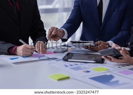 Group of confident business people point to graphs and charts to analyze market data, balance sheet, account, net profit to plan new sales strategies to increase production capacity, businesspeople.