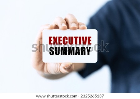 Executive summary text on blank business card being held by a woman's hand with blurred background. Business concept about executive summary.