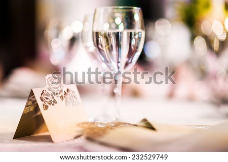 Wedding table. Close-up of wine glass and name card  