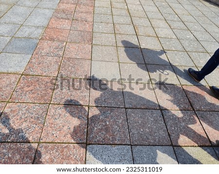 Shadows of several people on the ground on sunny day. Tourists on a journey. The concept of freedom in travel. Partially blurred focus