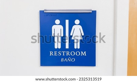restroom sign depicting gender icons of a woman and a man, symbolizing social issues surrounding gender identity and inclusivity