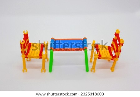 Mathematical Intelligence Stick blocks table and chairs models. Intelligent smart stick blocks plastic toy on a white background. Building blocks construction of a table and chairs.