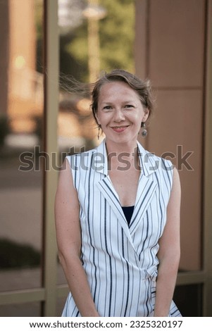 Urban summer portrait of a young blonde woman outdoors. High quality photo