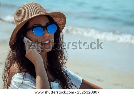 young woman on the beach talking on the mobile phone