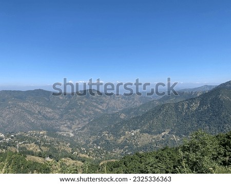 Breathtaking mountain scenery with distant snow-capped peaks under a vast blue sky. Perfect for travel and nature themes.