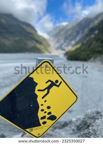 A rock falls warning sign at Franz Josef Glacier stream bed 