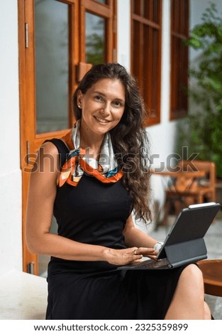 40 years old brunette business woman working with a tablet and looking at camera Royalty-Free Stock Photo #2325359899