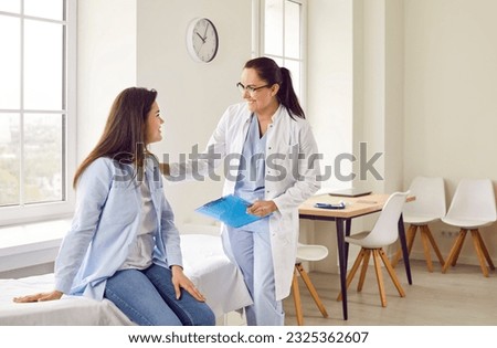 Happy young pregnant woman talking with her gynecologist doctor in hospital or medical clinic. Obstetrician doctor consulting female patient expecting a baby about pregnancy during check up. Royalty-Free Stock Photo #2325362607