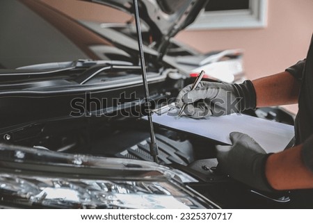 Close-up hand auto mechanic using the wrench to repairing car engine problem. Concepts of check and inspection car care maintenance and servicing. Royalty-Free Stock Photo #2325370717