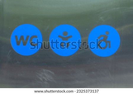 Information plate of public toilet. WC sign, baby sign, disabled sign - close-up. Design of icons in blue circle on metal background. Illustration label of water closet. Symbol of pointer on restroom.