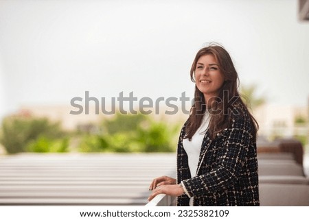 Portrait of stylish middle-aged adult lady businesswoman in park Dubai city, happy looking away. Smiling jewish woman in summer vacation, resting woman. Leisure activity concept. Copy ad text space Royalty-Free Stock Photo #2325382109