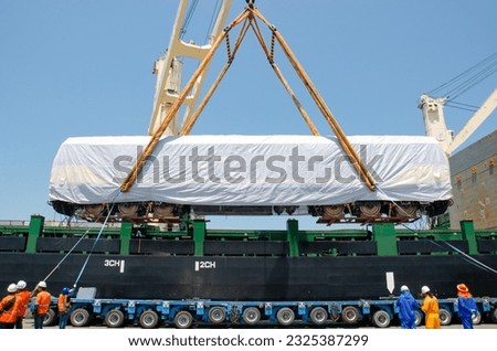 Unloading operation of project  cargo with port heavy lift cranes A crane on a large cargo ship docks loading a new diesel-electric locomotive.  at Laem Chabang Port   Royalty-Free Stock Photo #2325387299