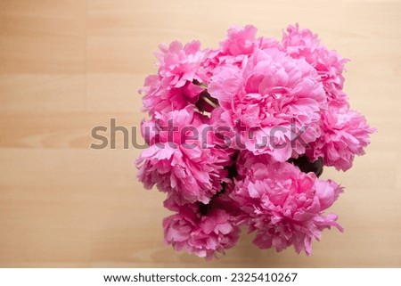 The peony or paeony pink flowers in the vase top view. Paeonia "Sarah Bernhardt" bouquet on wooden background