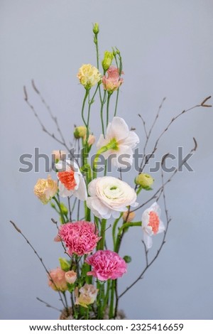 Flower arrangement vertically built in pots with white and pink flowers on the background of the wall of the house Royalty-Free Stock Photo #2325416659