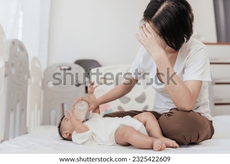 Tired Asian mother suffering from experiencing postnatal depression. Healthcare single mom motherhood stressful. Royalty-Free Stock Photo #2325422609