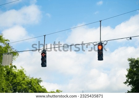 Gainesville, Florida city point of view driving with vertical road sign traffic red light signal and blue sky in background Royalty-Free Stock Photo #2325435871