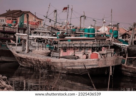 Fishermen's wooden boats lined up on the shore with residential residents in the background